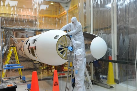 Scientist installing a fairing in a satellite 